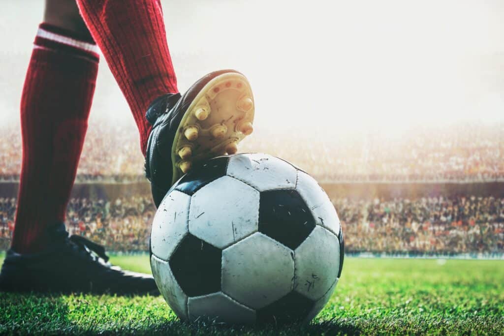 Close up from ground level of player with cleat on soccer ball