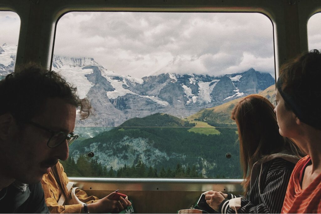Tourists on train looking at view of mountains