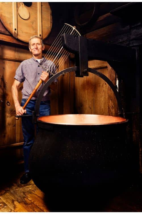 Traditional Alpine cheese maker holding a Swiss harp