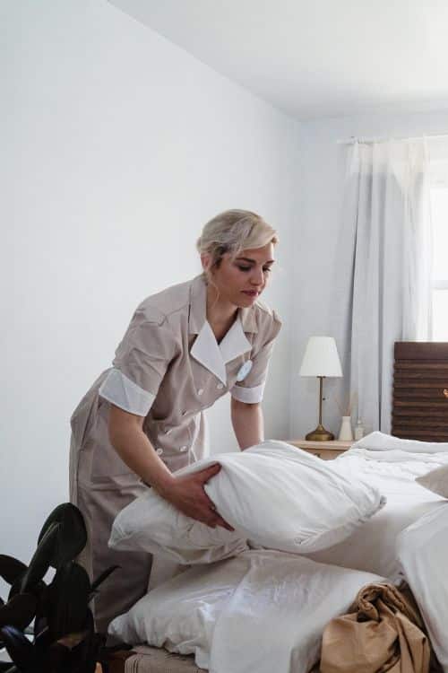 Hotel maid making bed vertical
