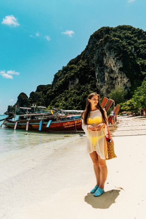 Vertical image of a tourist walking on a beach in Thailand